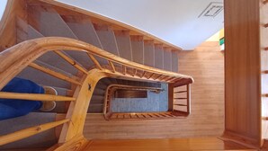 A wooden staircase with a handrail and a small wooden basket at the bottom. - The Steinbock Lodge (Zell am See)