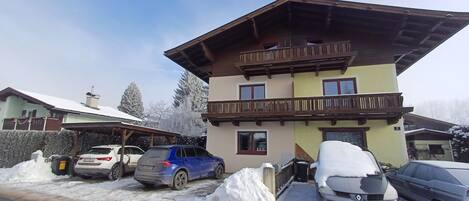 Stunning Alpine-style building with a balcony and snow-covered surroundings.