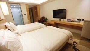 A hotel room with two beds, a desk, a TV, and a mirror. - Yuyang Hotel (Pinggu)