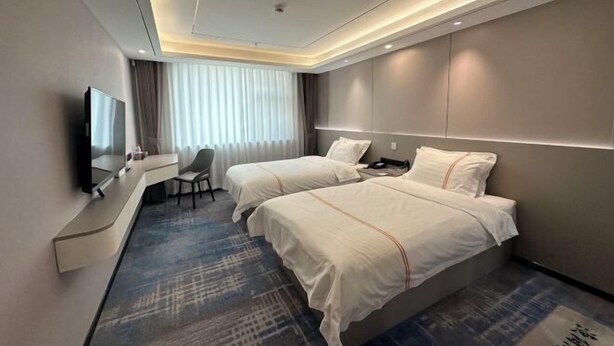 A modern hotel room with two beds, a desk, and a TV. - Yuyang Hotel (Pinggu)