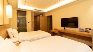 A hotel room with two beds, a TV, a wooden desk, and a bathroom door. - Yuyang Hotel (Pinggu)