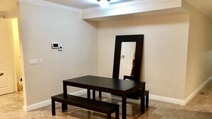 A dining area with a dark wooden table and bench, a large mirror on the wall, and a marble floor. - 4BR Townhouse 320 by Ideal Experience VR (Fort Lauderdale)