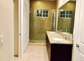 A bathroom with a walk-in shower, two sinks, and a large mirror. - 4BR Townhouse 320 by Ideal Experience VR (Fort Lauderdale)