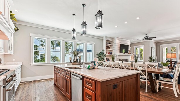 A spacious kitchen with a large island, wooden cabinets, and a dining area with a table and chairs. - Luxury 2nd Row Home, Chefs Kitchen, Pool, Free Golf, Great for Entertaining (Hilton Head)