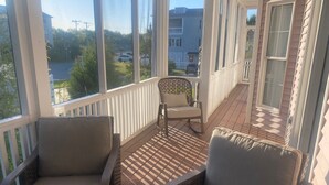 Ein überdachter Balkon mit Korbstühlen und Blick auf die Straße.