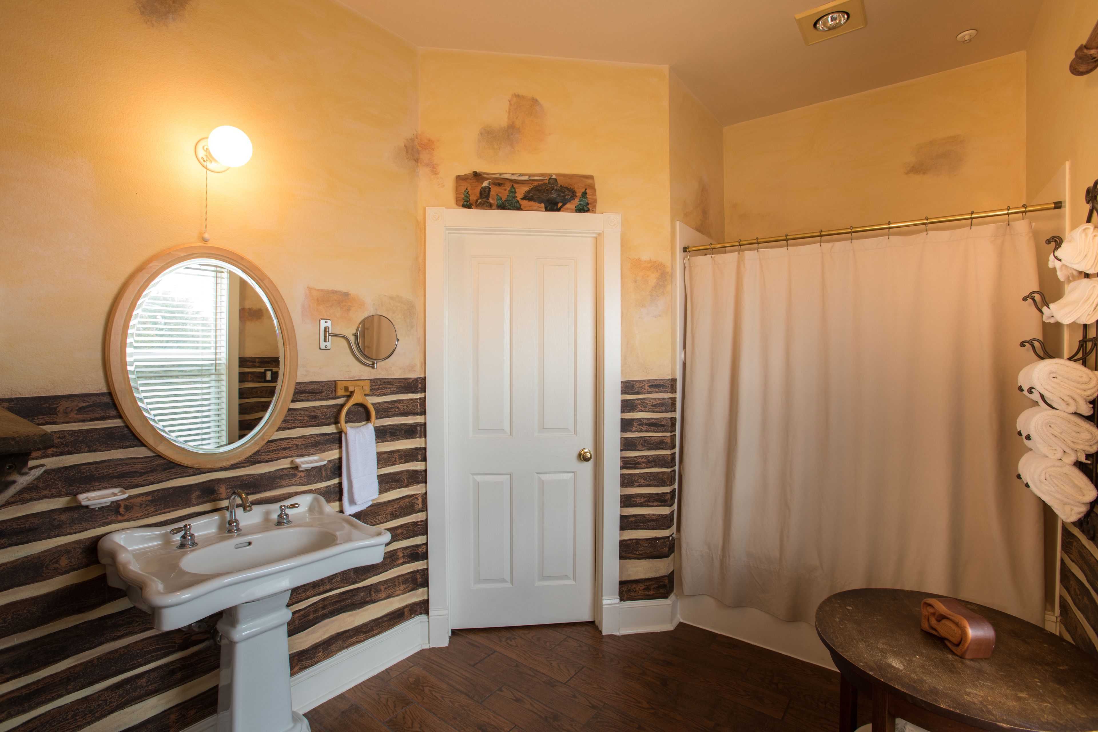 A bathroom with a sink, mirror, and a shower curtain.