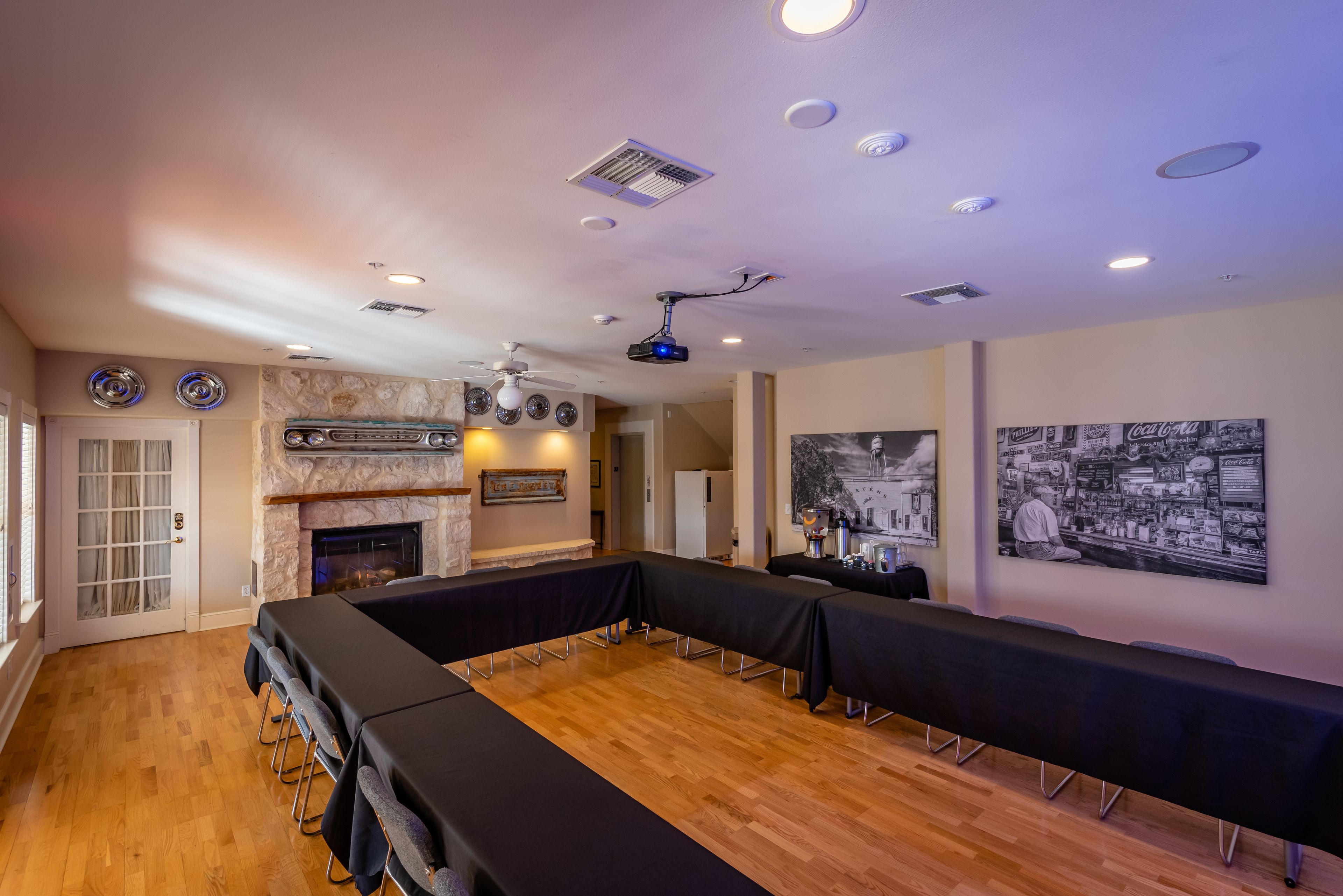 A conference room with a long table, a fireplace, and a projector.
