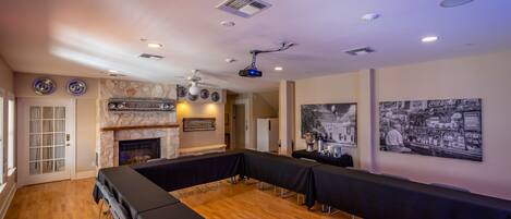 A conference room with a long table, a fireplace, and a projector.