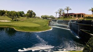 A golf course with a water feature, palm trees, and a building with a red roof. - LUXURY 2br/2baRemodel in the HEART of Scottsdale! HEATED POOL, GYM, TENNIS COURT (Scottsdale)