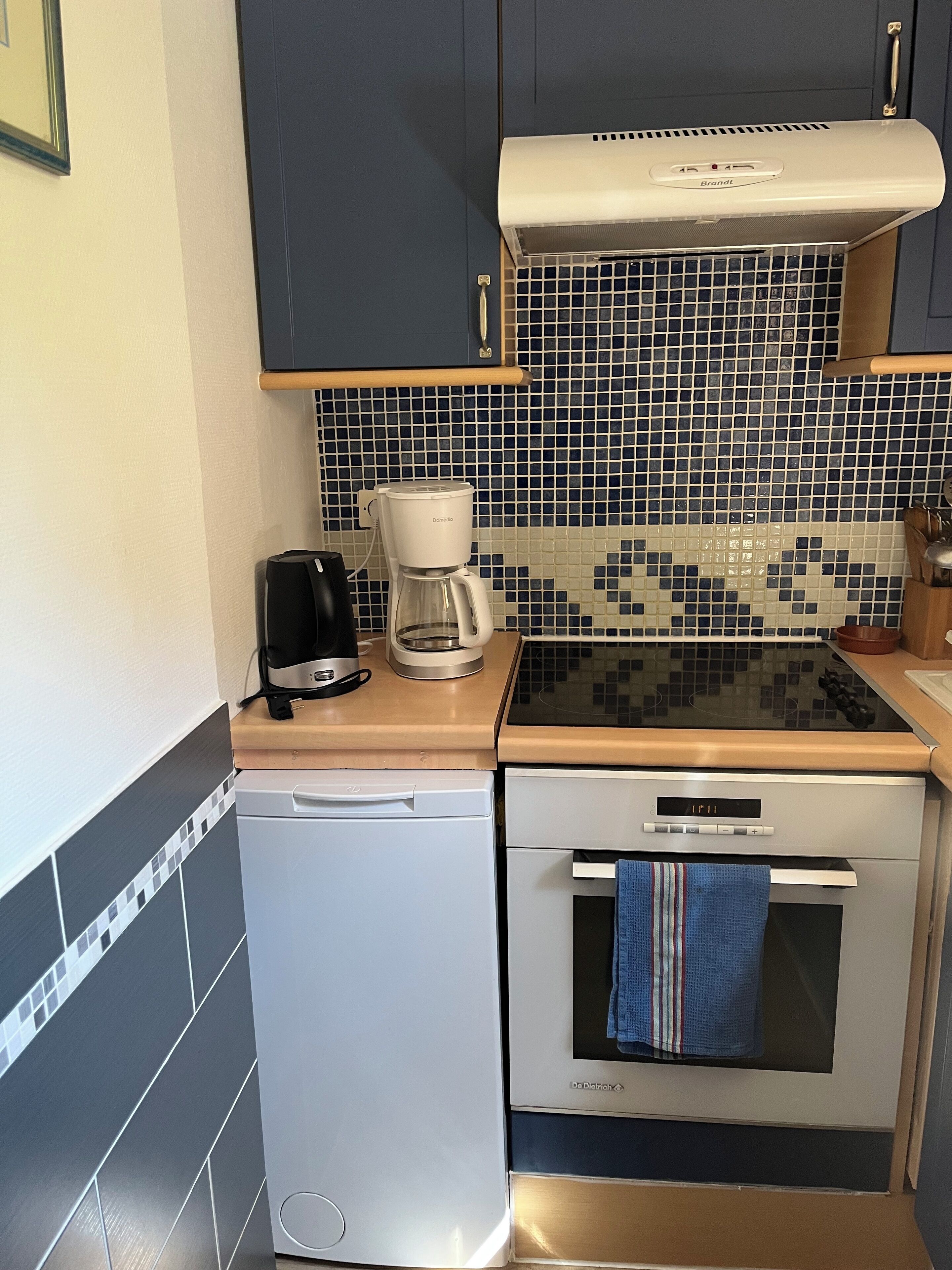 Cocina compacta con cafetera, tostadora, lavavajillas y estufa.