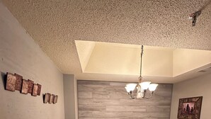 A dining area with a wooden table and chairs, a wooden bench, a chandelier, and a wall with a wooden panel and framed pictures. - 2nd Floor 'Sky Rise Vista' - Pool Access! (Sugar Mountain)