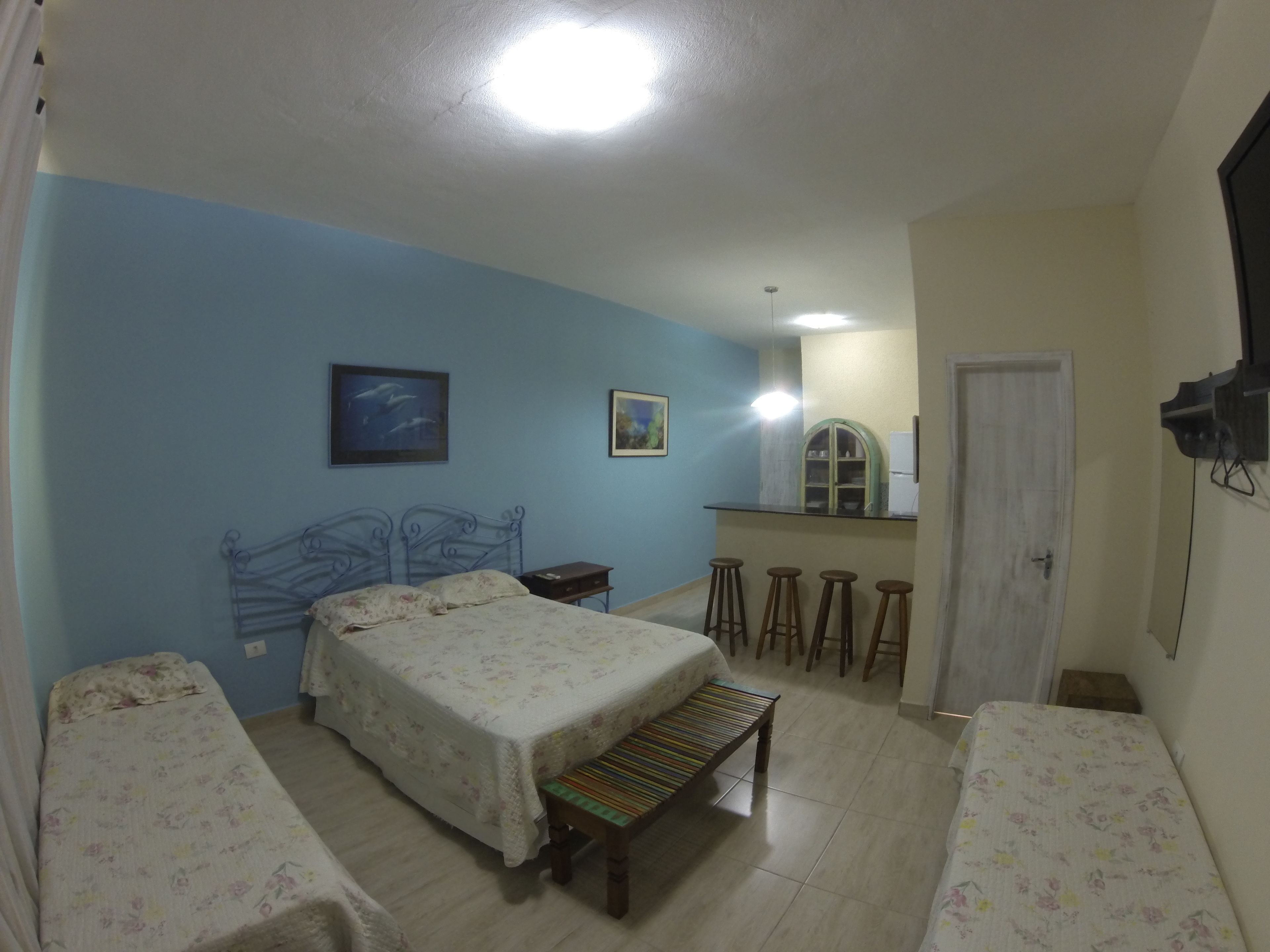 Een slaapkamer met twee bedden, een bankje, een klein tafeltje en een spiegel.