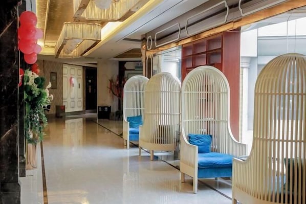A hotel lobby with a polished floor, a chandelier, and white birdcage-style seating with blue cushions. - Bonway International Hotel (Shiyan)