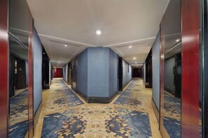 A hotel corridor with carpeted floors, wooden walls, and doors leading to rooms. - Bonway International Hotel (Shiyan)