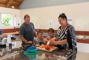 A kitchen with stainless steel appliances, a window with greenery outside, and a counter with a lobster. - Russell Top 10 Holiday Villas (Russell)