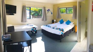 A hotel room with two beds, a TV, a desk, and a chair. - Russell Top 10 Holiday Villas (Russell)