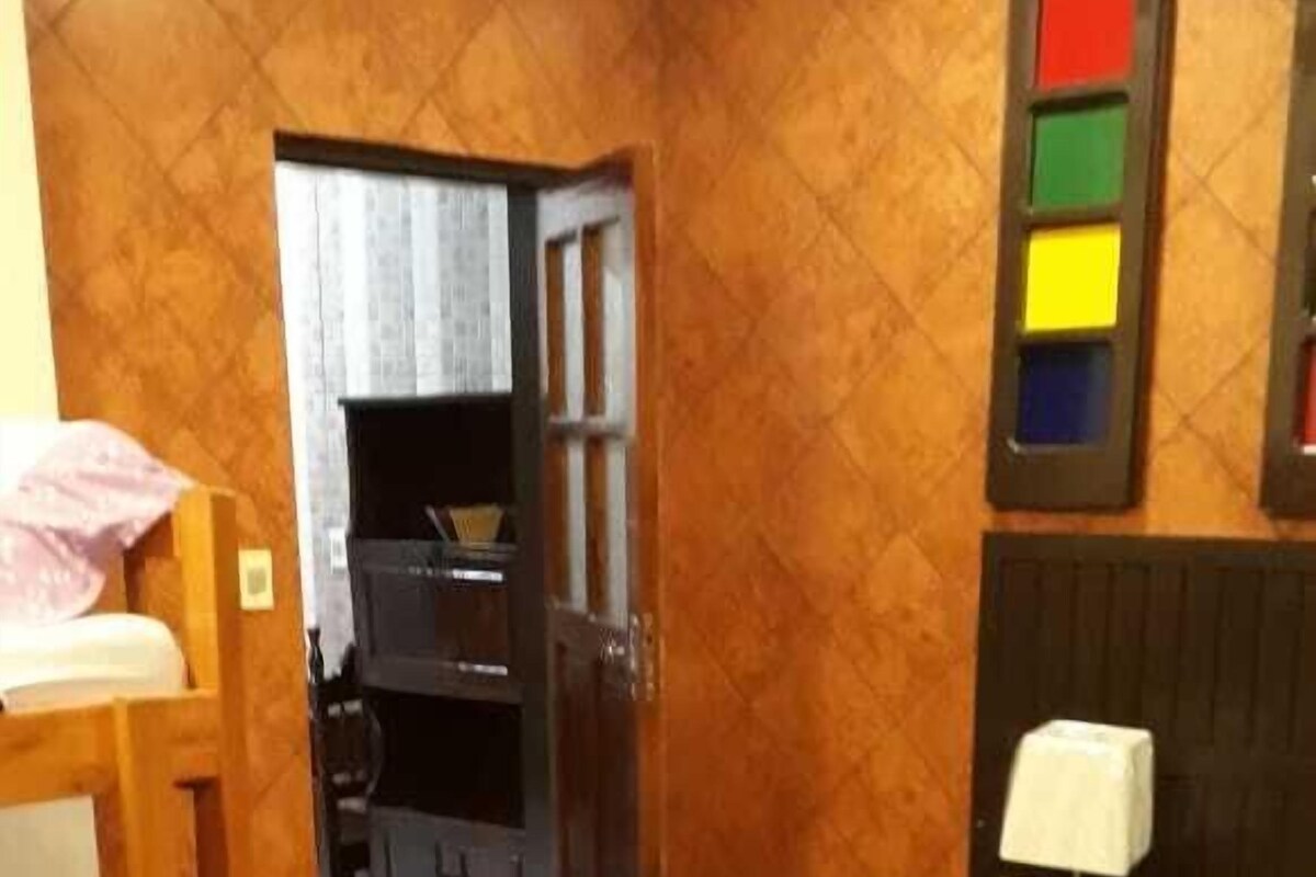 Een hotelkamer met een bed, een bureau, een stoel en een kledingkast.