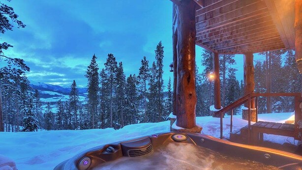 A hot tub with a view of snow-covered trees and mountains in the background. - Ten Mile Estate: Private Breckenridge Home with Hot Tub and Views (Breckenridge)