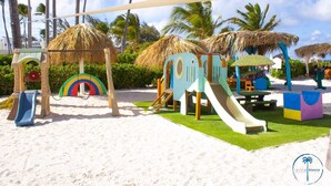 Un parque infantil en la playa con toboganes y juegos.