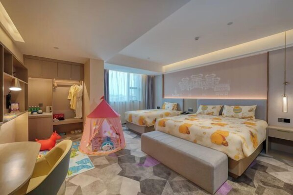 Ein Hotelzimmer mit Bett, Schreibtisch, Stuhl, Kleiderschrank, einem pinken Spielzelt und einem großen Fenster.