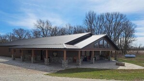 A building with a covered porch, stone pillars, and a gravel driveway. - Lost Branch Lodge. Complete exterior remodel, spring 2026! (Brashear)