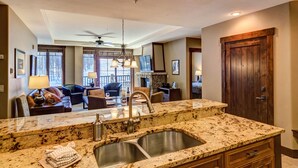 A kitchen with granite countertops, stainless steel sinks, and a ceiling fan. - ON THE SLOPES. FAST RESPONSE. Ski Side Corner Unit, Crystal Peak Lodge 2BR/2BA (Breckenridge)