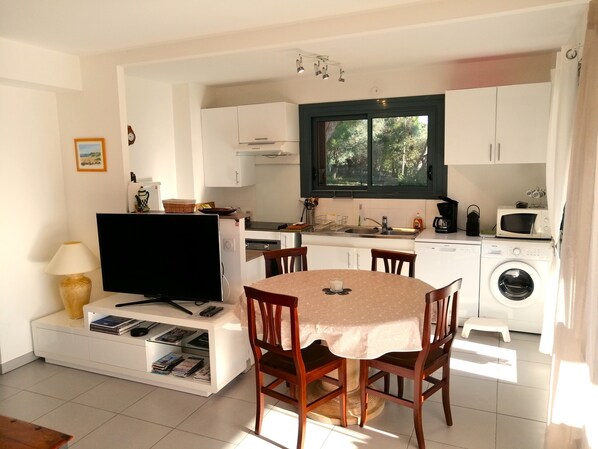 A compact living space with a dining area, kitchenette, and laundry facilities. - 🌊🌞 ***** Seafront Premium Apartment – 65 m² – Elegance & Serenity (La Ciotat)