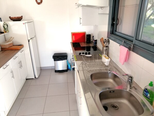 A kitchen with white cabinets, a stainless steel sink, and a window. - 🌊🌞 ***** Seafront Premium Apartment – 65 m² – Elegance & Serenity (La Ciotat)
