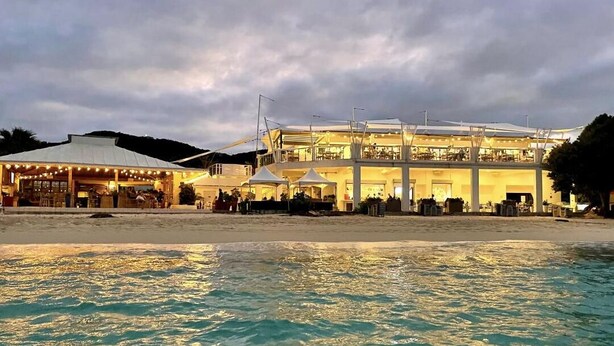 Ein Strandhotel mit einem großen Gebäude, Außenbereich und Poolanlage.