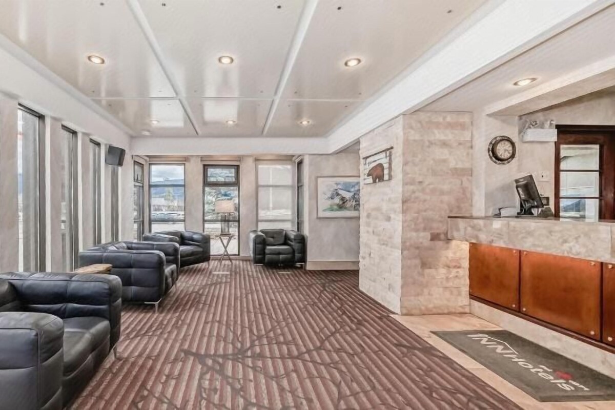 Amplia habitación con asientos de cuero, mostrador de recepción y grandes ventanales con vistas.