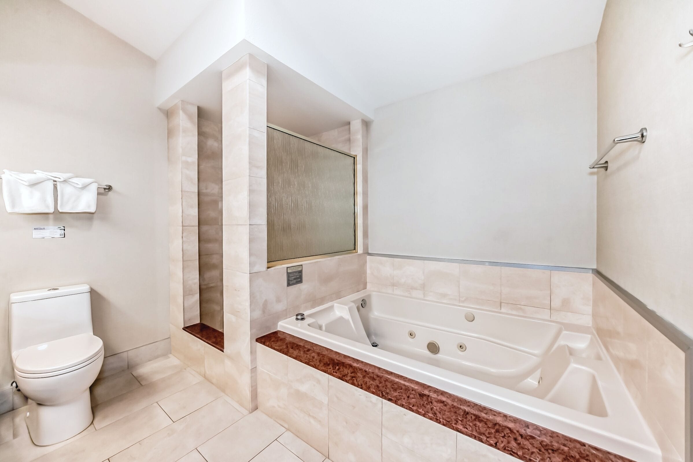 A modern bathroom with a toilet, a bathtub, and a shower area.