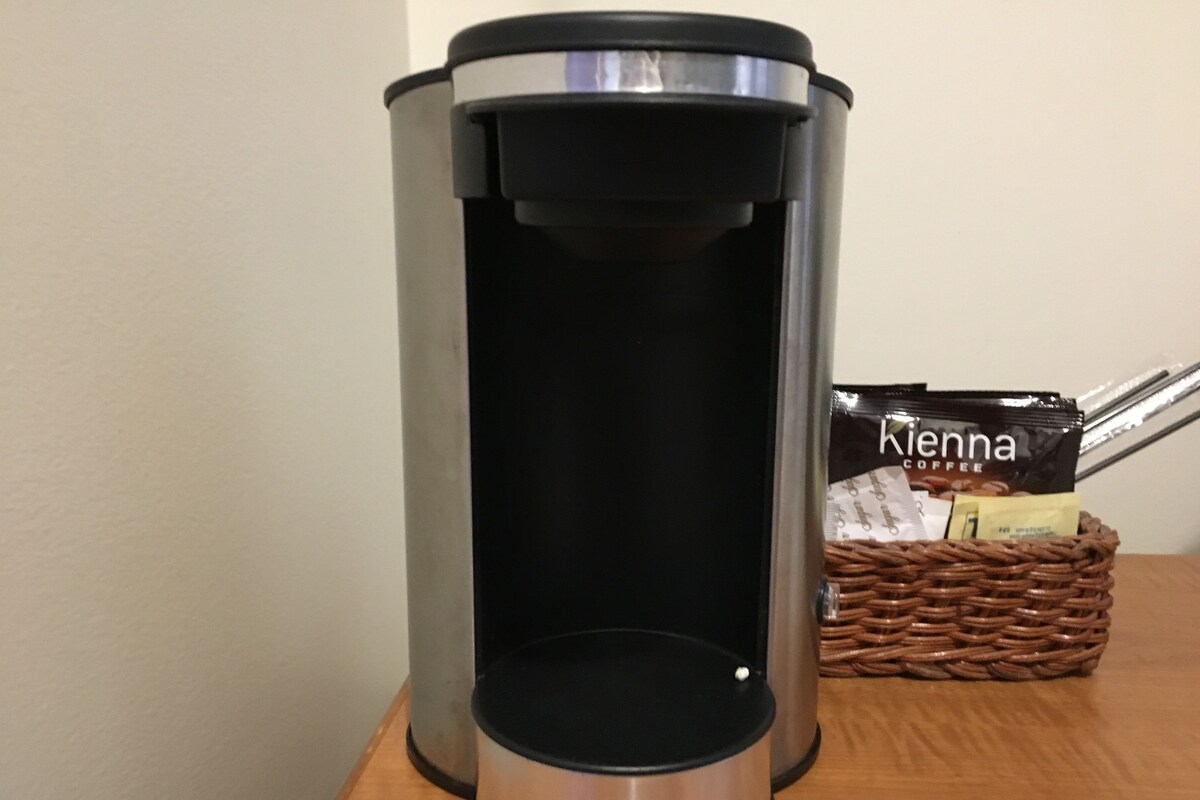 A Cuisinart coffee maker with a coffee pod holder beside it.