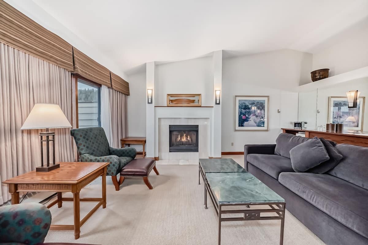 A living room with a fireplace, a sofa, a chair, and a coffee table.