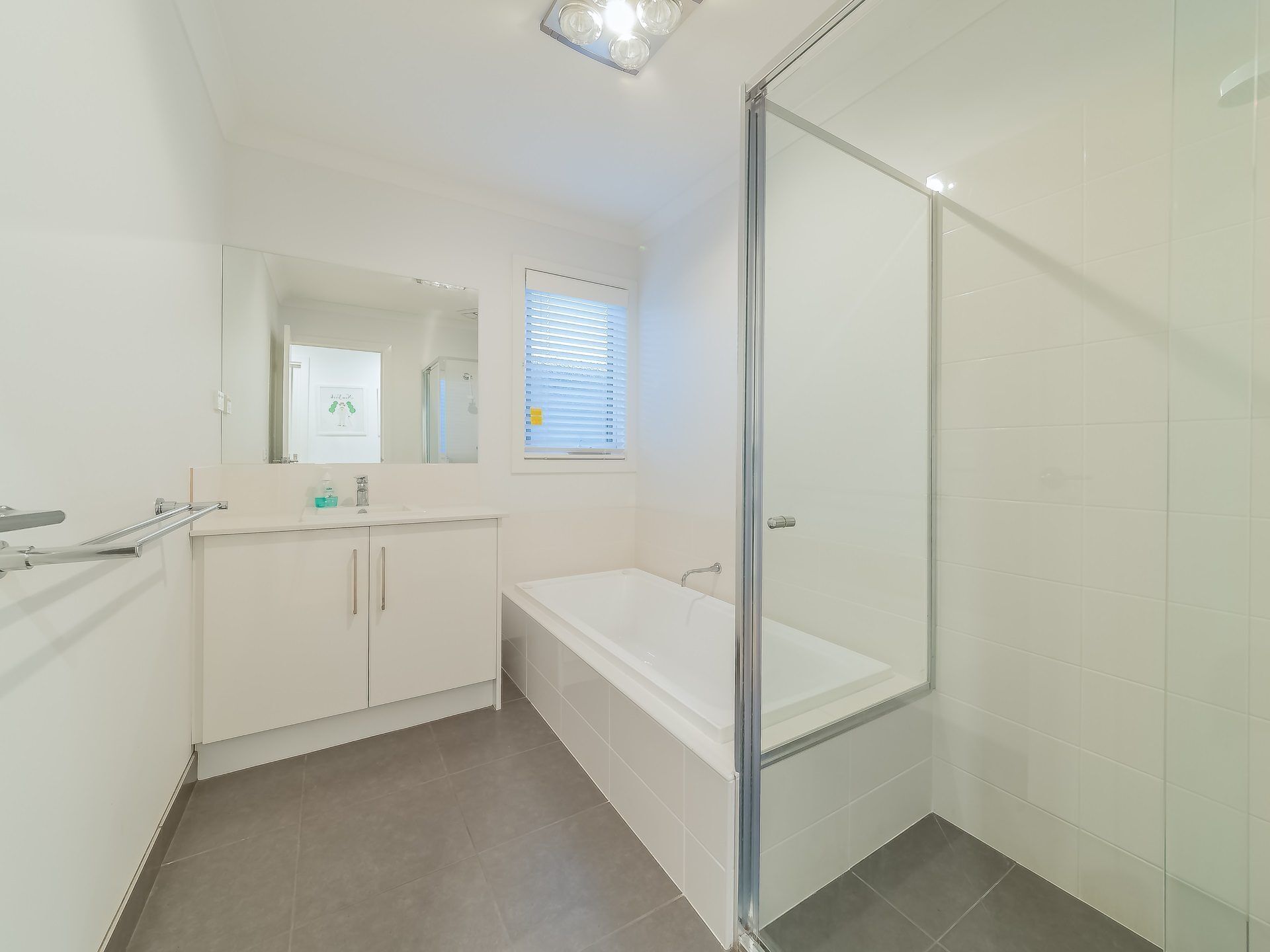 Un baño moderno con cabina de ducha de vidrio, un lavabo blanco y una bañera.