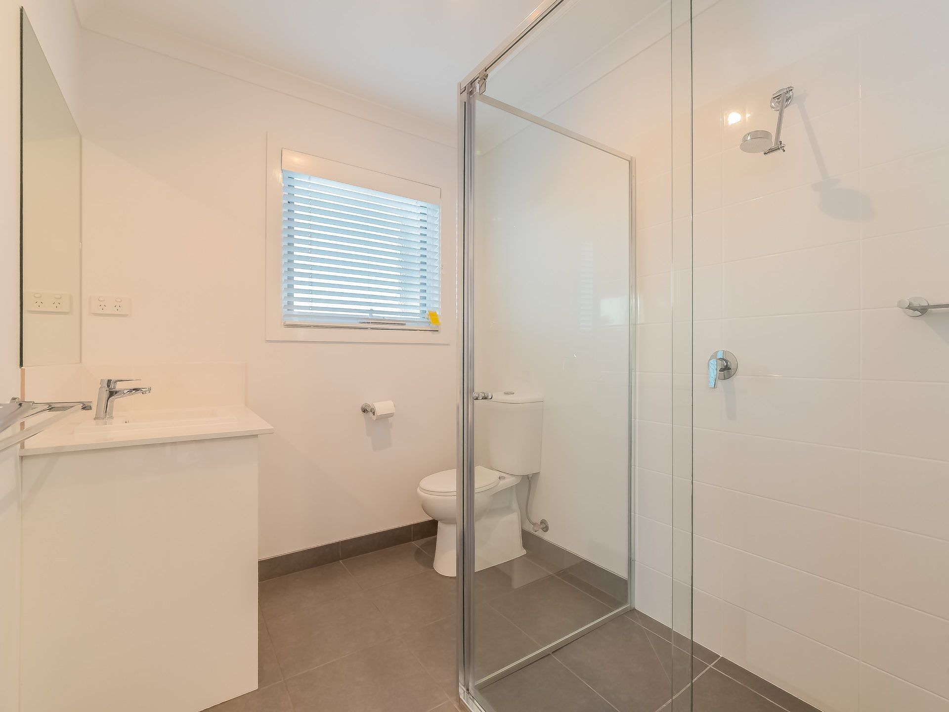 Une salle de bain moderne avec une douche à l’italienne, des toilettes et un lavabo.