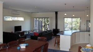 A modern living room with a sofa, TV, and dining area. - Red Rocks Road, Beach House in Cowes, bring the family! (Cowes)