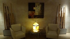A room with two armchairs, a table with a lamp, and a painting on the wall. - Hotel Luminton (Mar del Plata)