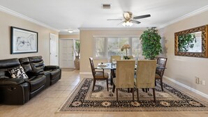 A dining area with a table and chairs, a ceiling fan, and a large plant. - Perfect for big family reunions, sport teams! (Fort Myers)