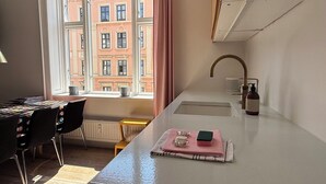 Una cucina moderna con una finestra, un lavandino e un tavolo con sedie.