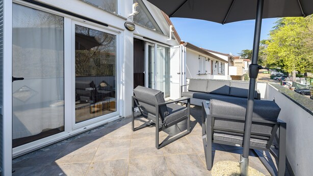 A patio with a sliding glass door, outdoor furniture, and a large umbrella. - Two bedroom holiday apartment in a touristic village, near the beach - Susanna 3 (Umag)