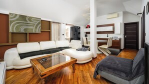 A modern living room with a white sofa, a wooden coffee table, and a grey armchair. - Two bedroom holiday apartment in a touristic village, near the beach - Susanna 3 (Umag)