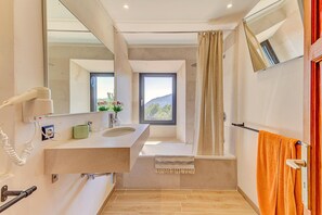 Banheira, secador de cabelo, toalhas de banho 