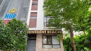 En bygning med et skilt, der viser ”Sunshine Beach”, og et ”HUE Luxury” skilt over det.
