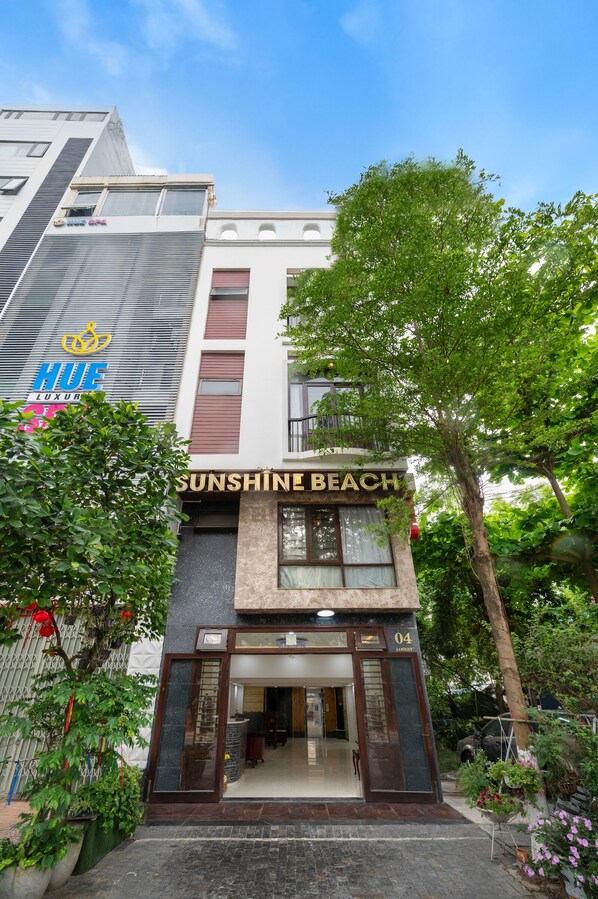 A building with a sign reading "Sunshine Beach" and a "HUE Luxury" sign above it.