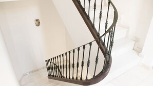 A spiral staircase with a dark wooden handrail and black balusters. - Charming apartment in the Historic Center ideal for couples and families (Málaga)