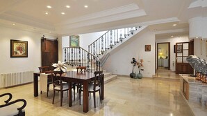 A spacious dining area with a high ceiling and a staircase leading to an upper level. - Can Gual de Inca, Elegant Vila, Mallorca (Inca)