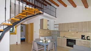 Een moderne keuken met een eethoek, een trap en een woonkamer.