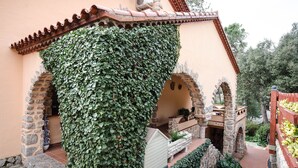 A stone building with a covered patio area, stone walls, and a small garden.