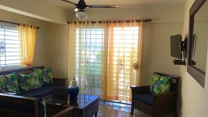 Una sala de estar con sofá, sillas, una mesita de centro y un ventilador de techo.