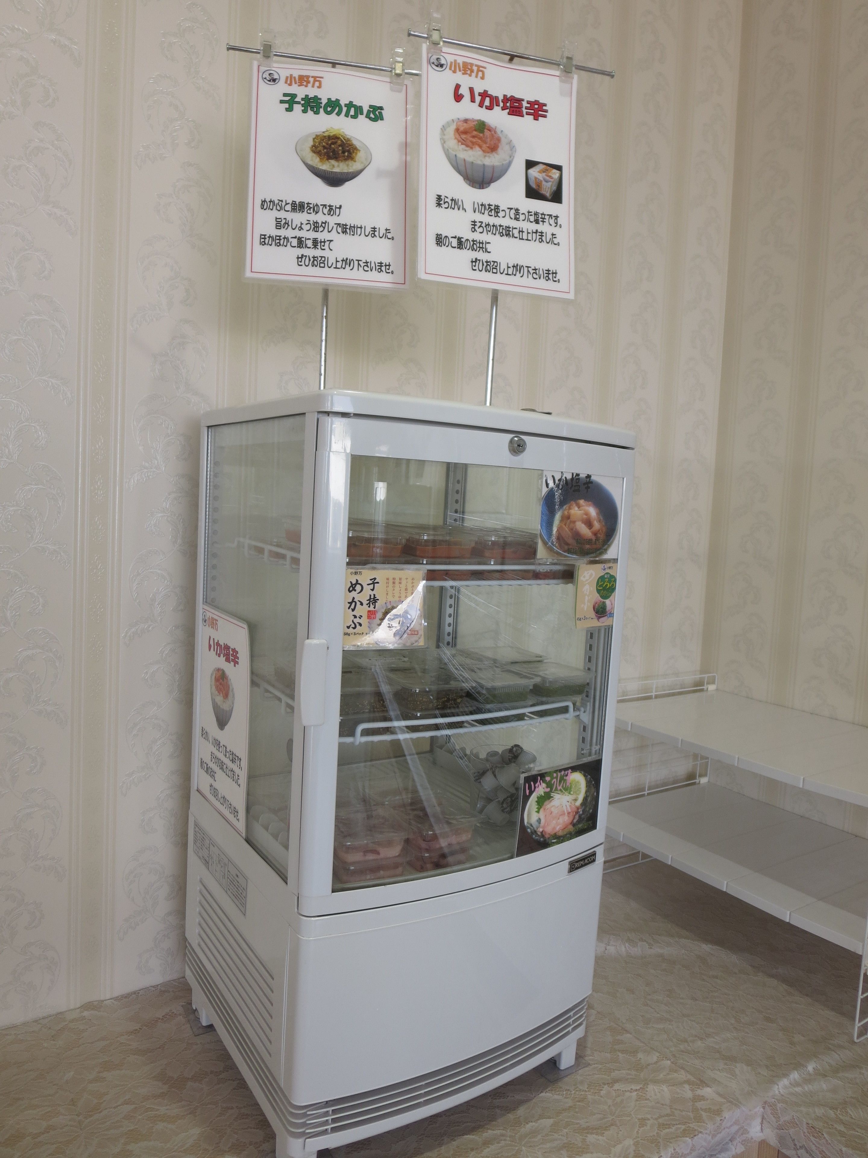 A food vending machine with two signs above it, one for 'Miso Soup' and one for 'Ika Momen'.